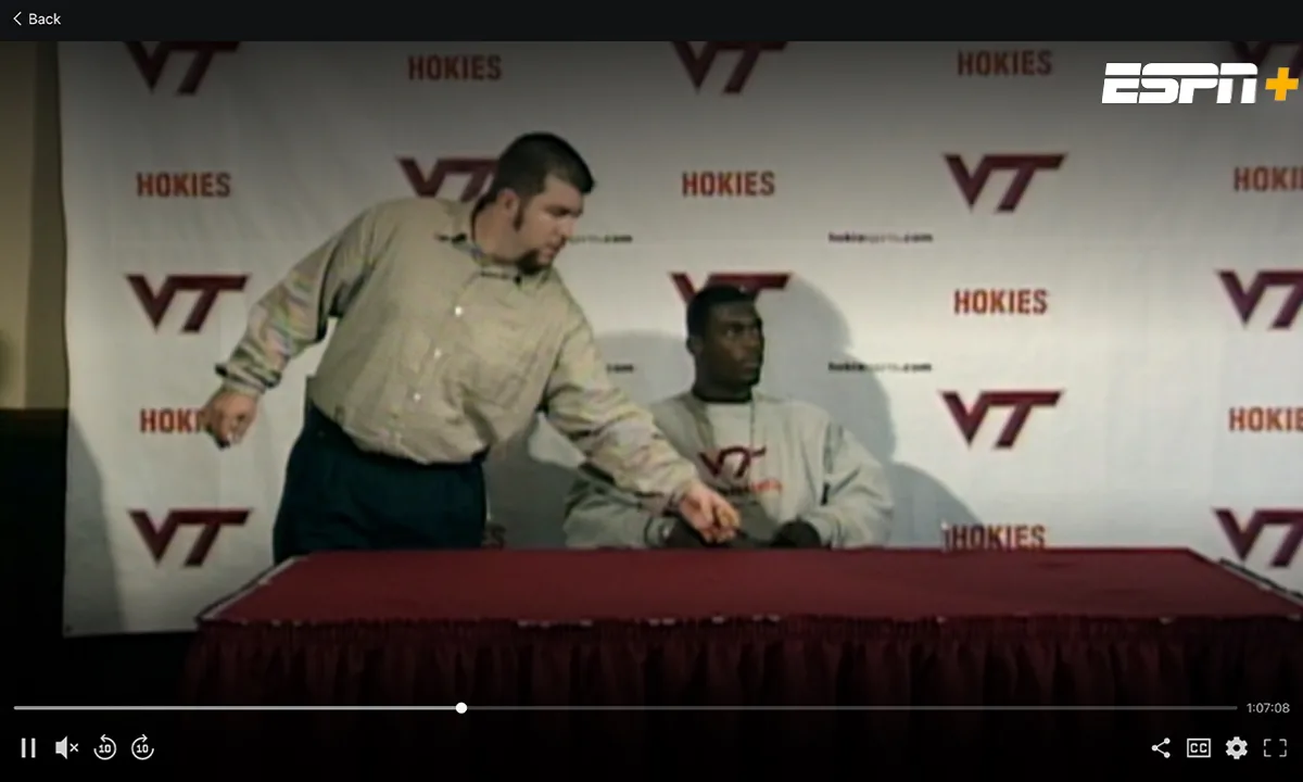 ESPN+ NFL Doc Archival footage of former NFL player Michael Vick during a press conference, with the ESPN+ logo on the top right of the screenshot.