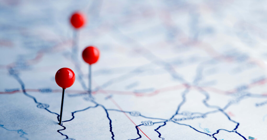 Three pins stuck into a paper map