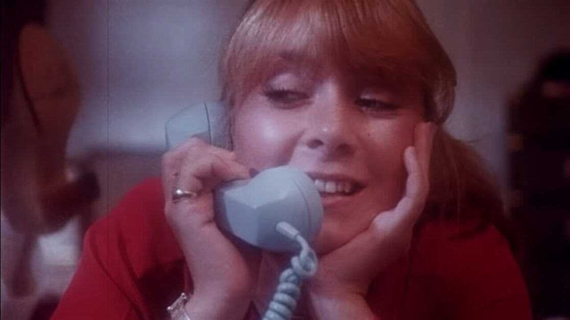 A teen girl talks on the telephone.