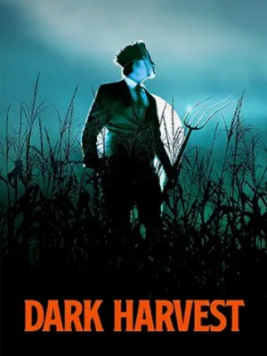 A teen boy in a suit holds an ax as he looks over his shoulder in a cornfield.