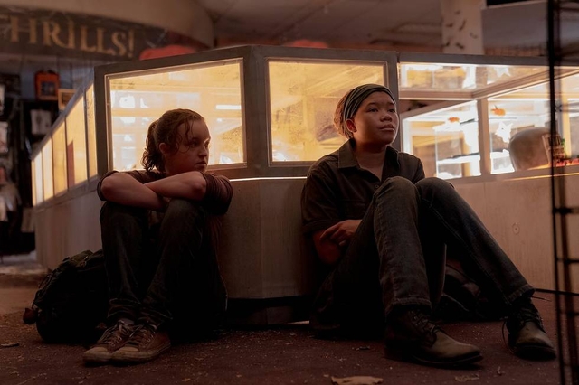 Bella Ramsey and Storm Reid sitting by a countertop in HBO's The Last of Us.