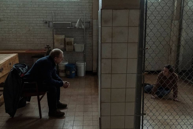 David and Ellie talking in a prison cage from HBO's Last of Us