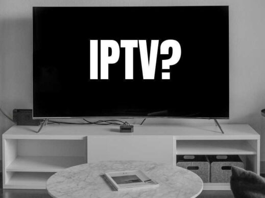 A living room scene where a black TV screen has white text reading "IPTV?" (Photo: Andres Jasso on Unsplash. Cropping and text by CableTV.com)