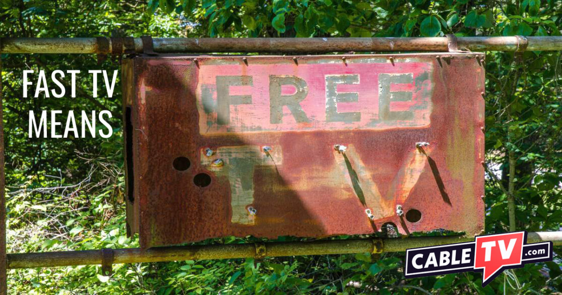 Among trees sits a rusty sign saying, FREE TV.