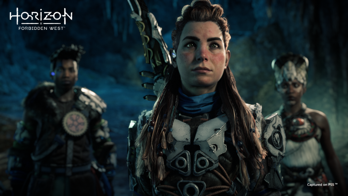 A PS5 screenshot of Horizon Forbidden West. Aloy and two characters are facing the camera.