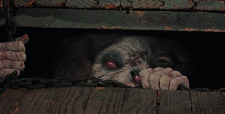 Una Deadite cerca di uscire da un seminterrato in cabina in The Evil Dead di Sam Raimi