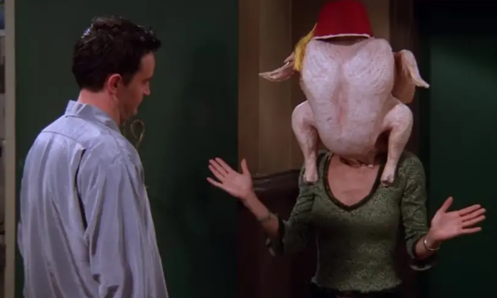 Chandler looks at Monica, who is wearing an uncooked turkey carcass on her head, obscuring her face. It's very disturbing.