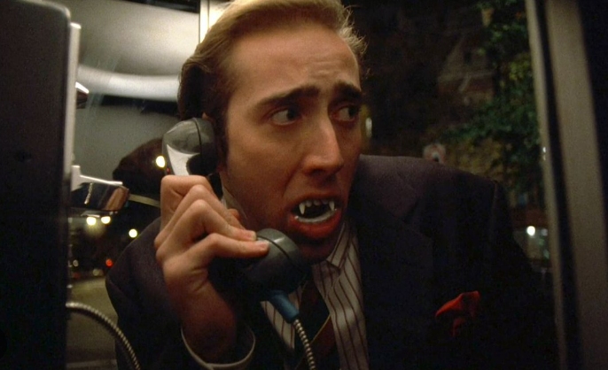 Nicholas Cage as Peter Loew in a phone booth rocking plastic fangs in Vampire's Kiss