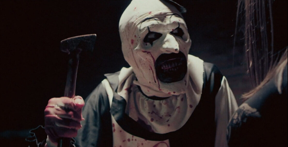 Terrifier's Art the Clown brandishing a hatchet—and his mouthful of bloody teeth.