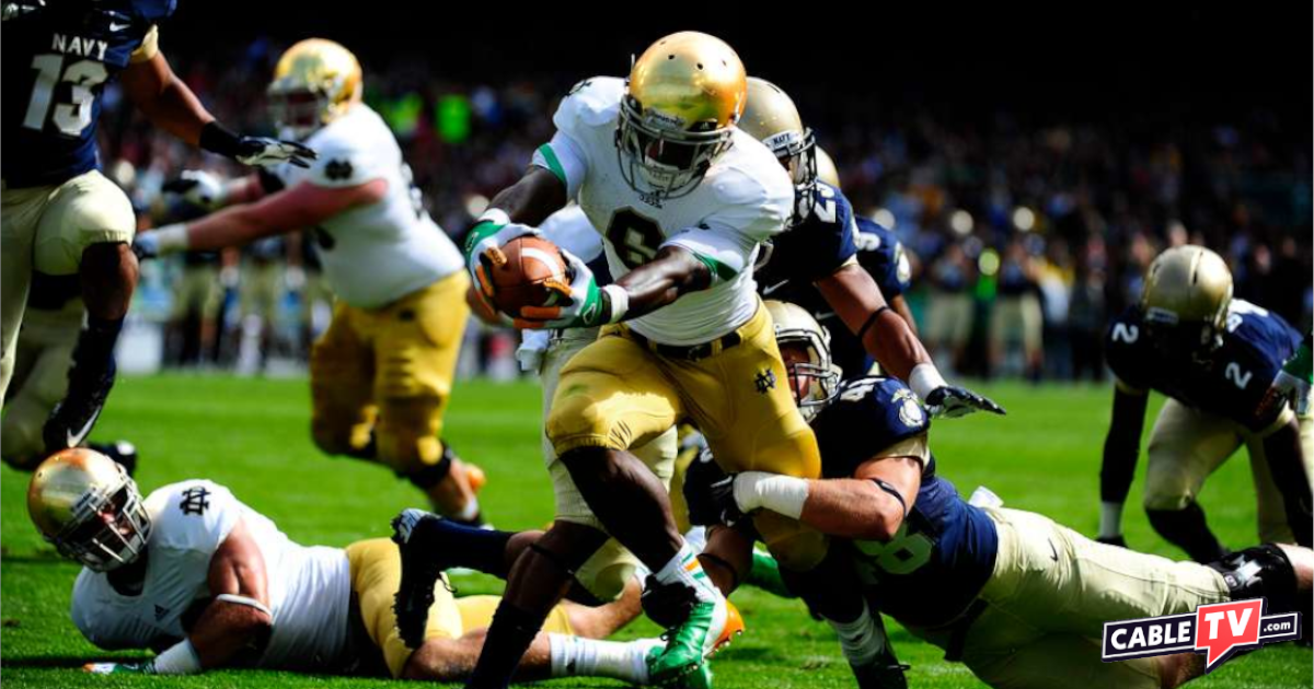 Notre Dame running back Theo Riddick stretches over the goal line during the NCAA Emerald Isle Classic college football season opener in Aviva Stadium. Image courtesy U.S. Navy.