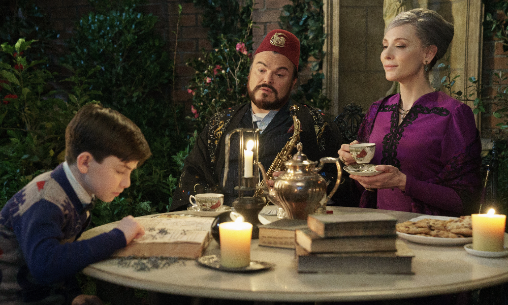 Eccentric characters played by Jack Black and Cate Blanchett watch over a small boy while he reads a book.