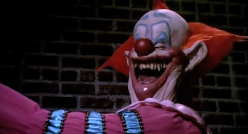 A killer clown smiles, baring its fangs.