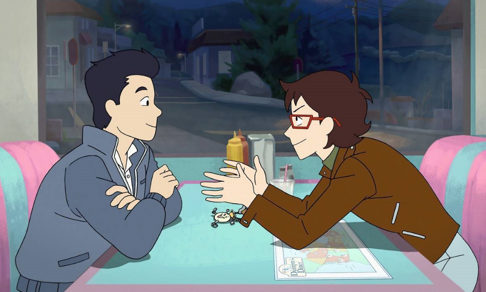Two boys, one with short black hair and one with medium length brown hair and glasses, at a colorful diner booth.