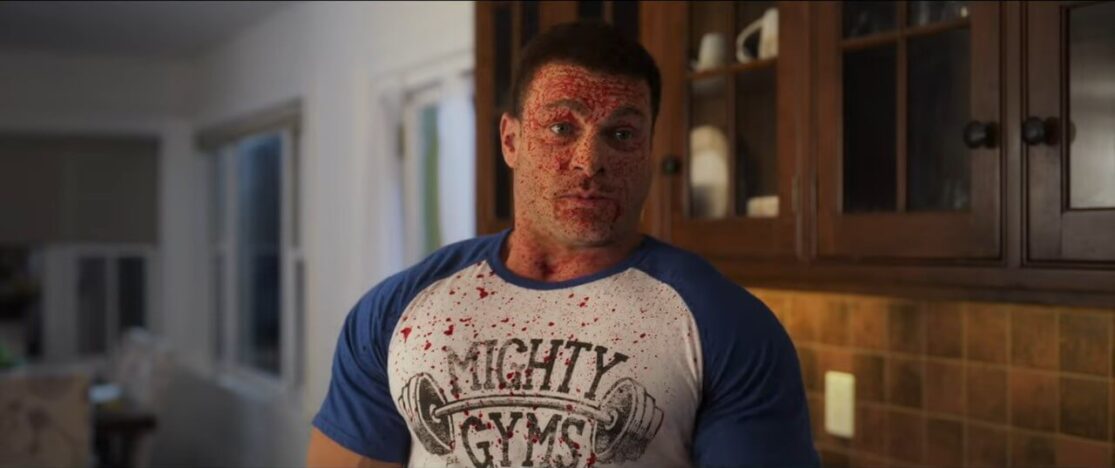 A musclebound pro wrestler type covered in blood spatter.