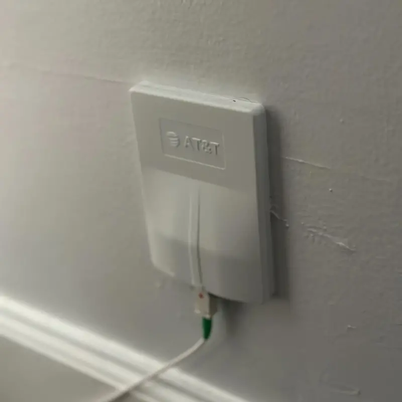 Image of AT&T's wall-mounted ONT device for fiber intenret. It's a cell-phone sized box mounted to a wall in a home.