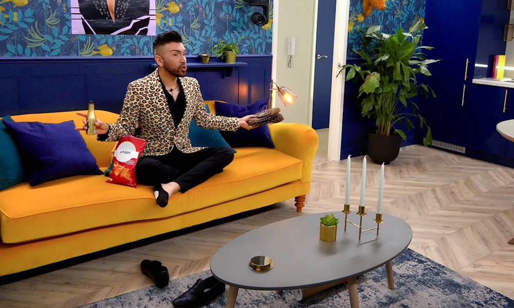 A man sitting on a couch in a colorful room.