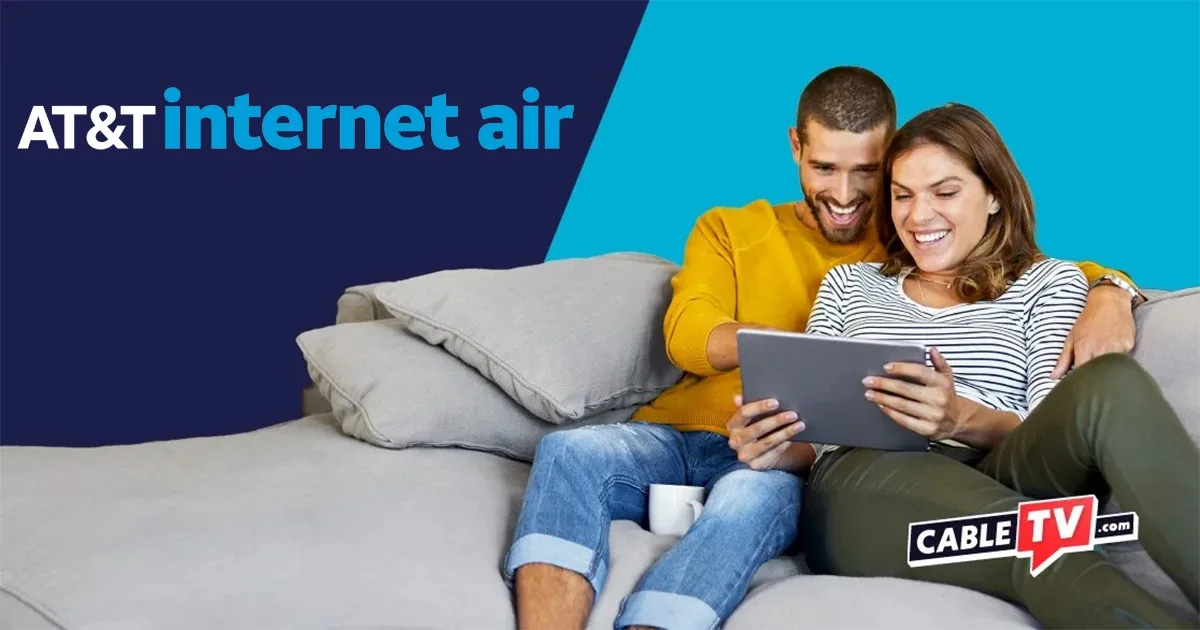 Man and woman sitting on couch looking at tablet