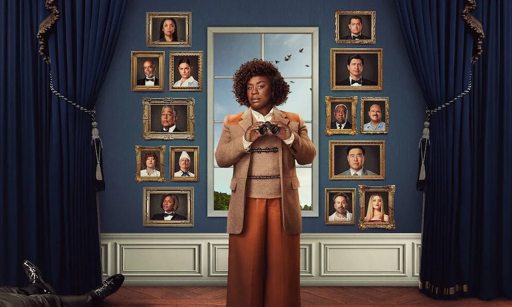 The Residence on Netflix A woman in a tweed jacket holds up binoculars in front of a wall of framed portraits. A dead body sits in the background.
