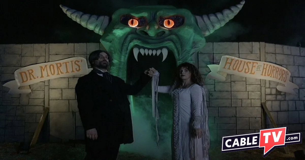 A ghoulish-looking bride and groom appear to welcome visitors to a haunted house. It's a scene from V/H/S/Halloween, one of many upcoming horror movies covered here.