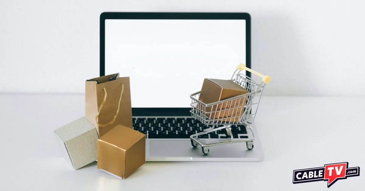 Open laptop with tiny shopping cart and boxes for Cyber Monday Deals