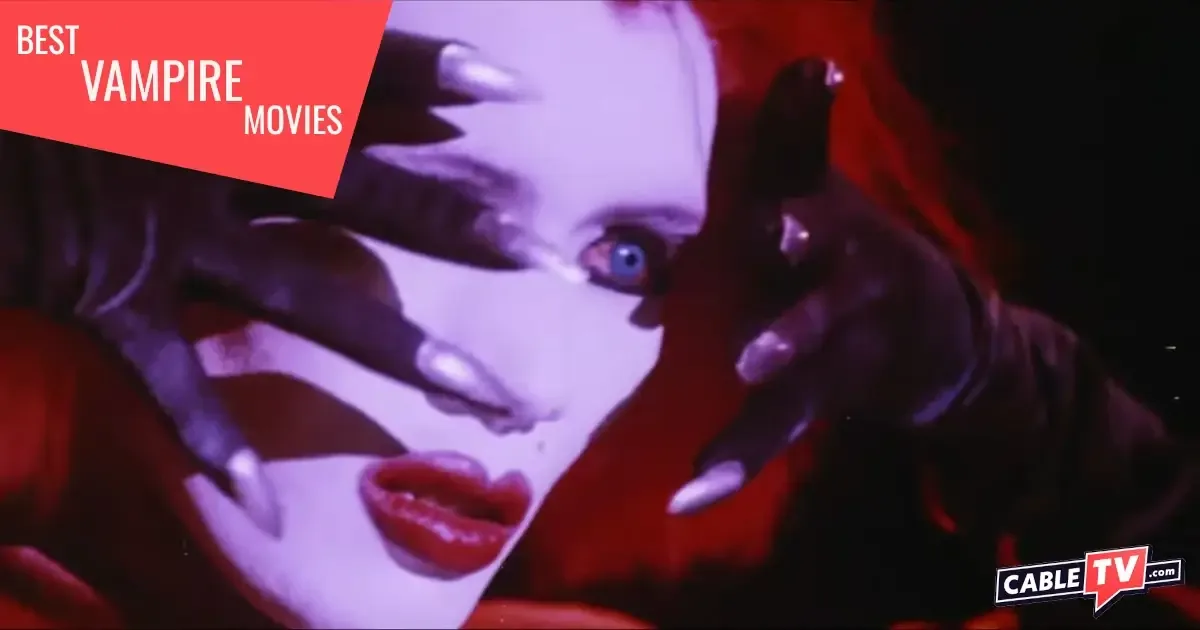 A vampire in heavy makeup peeks out from behind clawed hands.