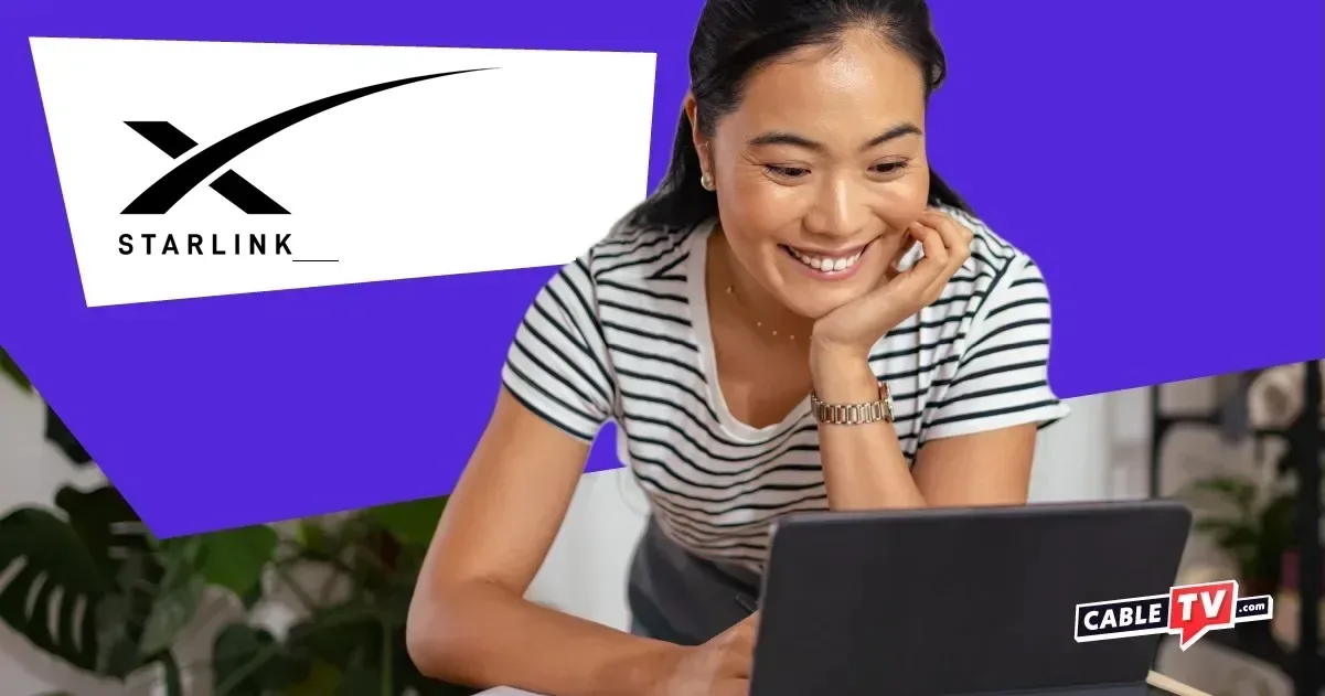 Woman smiling and looking at a laptop with Starlink logo in top left