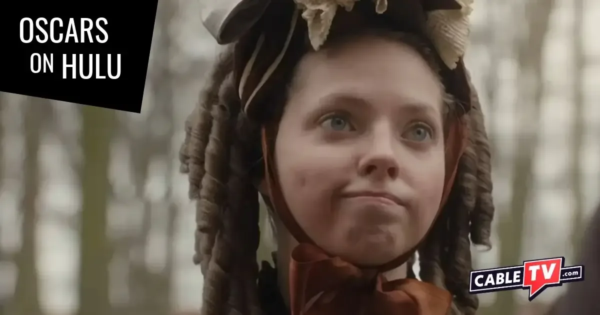 A young girl in Victorian dress makes a semi-apologetic face.