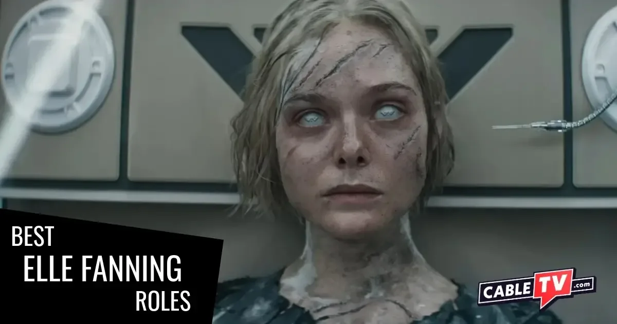 A battle-scarred young woman with milky cybernetic eyes is about to be probed in the ear by a needle. A scene from "Predator: Badlands," one of the Elle Fanning movies covered in this article.