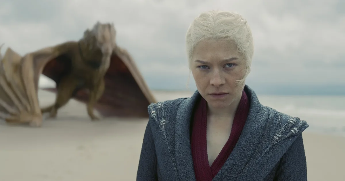 Rhaenyra standing in front of a golden dragon.