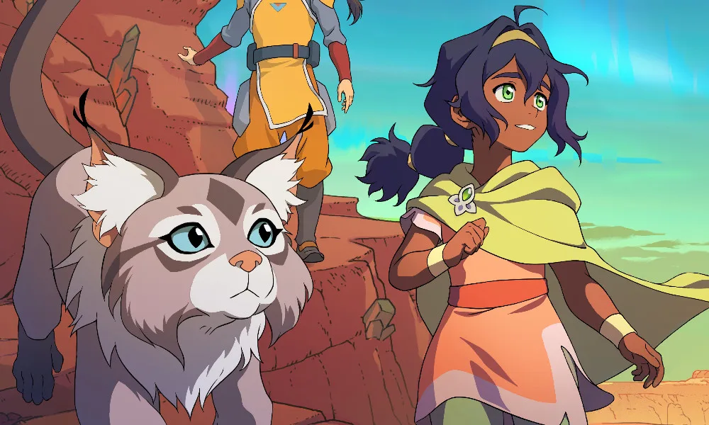 A young earthbender in a cloak smiles and walks alongside a cat creature through a slightly post-apocalyptic desert.