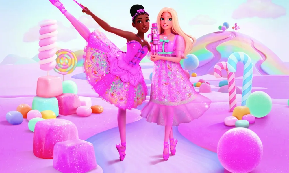 Brooklyn Barbie, a Black woman in a bright pink tutu, poses next to Malibu Barbie, a blonde woman in a bright pink nightgown holding a pink nutcracker. The whole image is very saturated, and the two are standing in a land made of sweets.