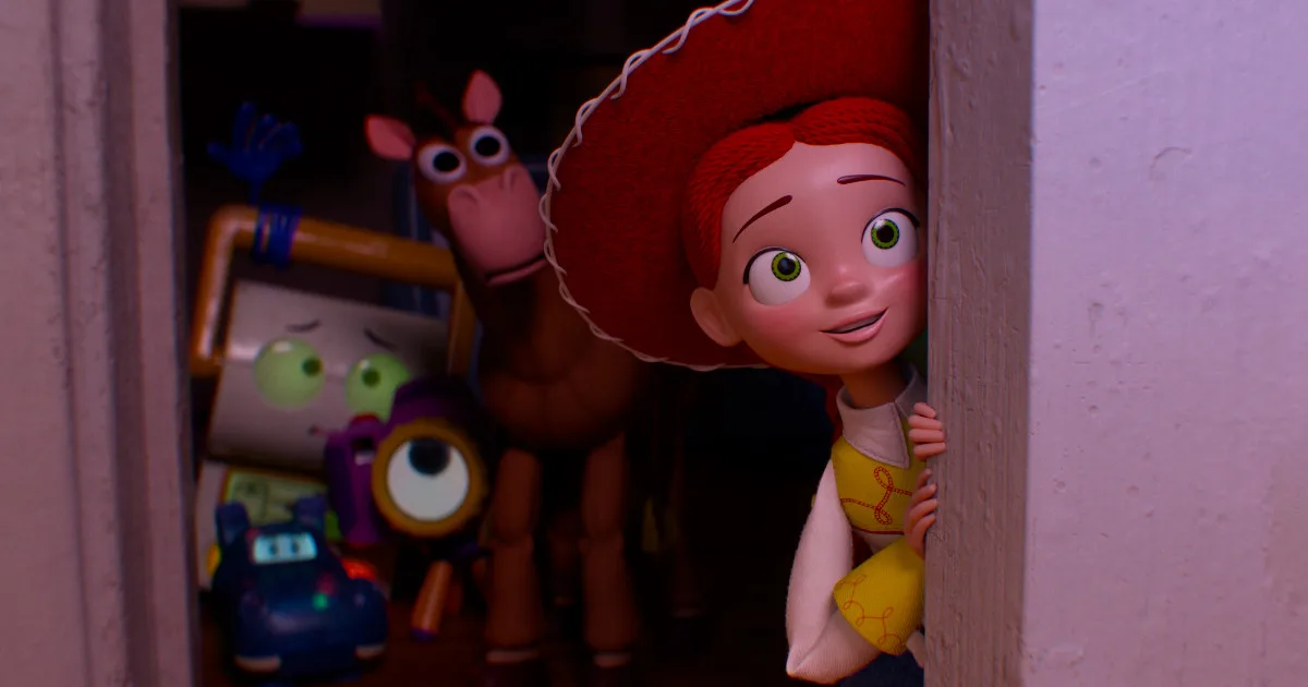 Jessie, a cowgirl doll, smiles while looking around the corner at something behind the camera. Other toys stand behind her, looking nervous.