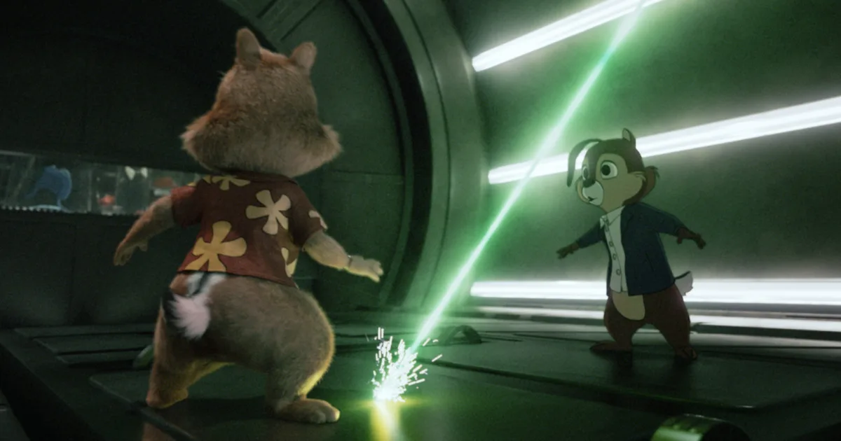 Two cartoon chipmunks stand in a machine with a green laser. One chipmunk is 3D, the other 2D.