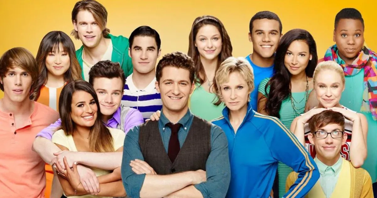 Glee1200x630 The cast of a later season of "Glee," with all of the students standing around Mr. Schue and Sue Sylvester on a bright yellow background.
