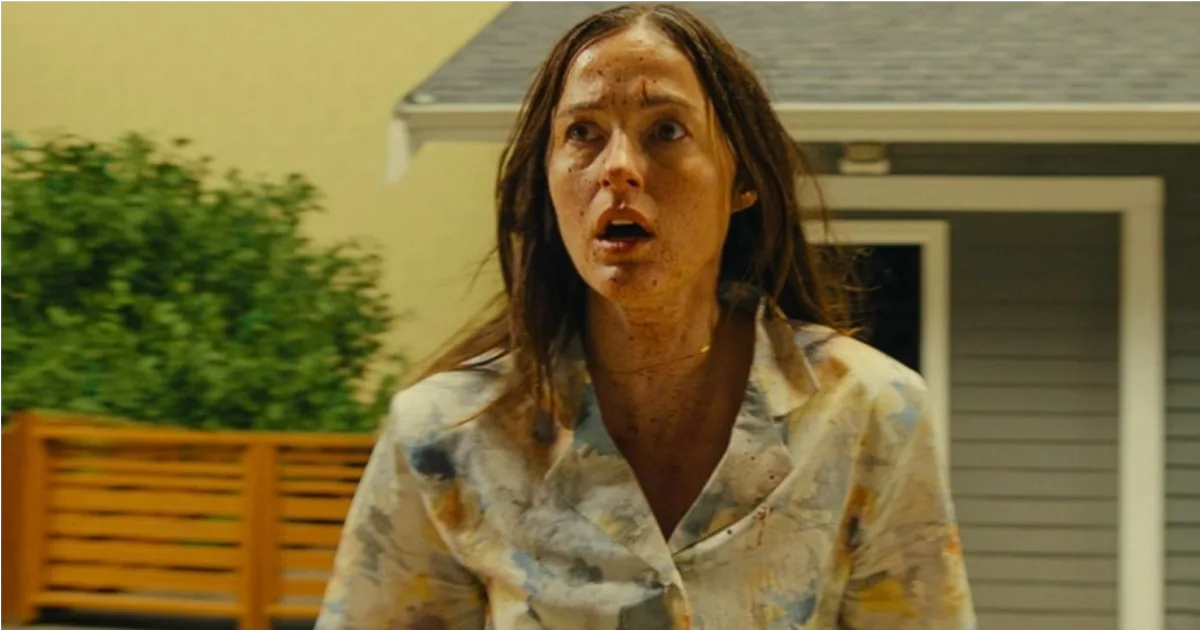 Dr. Mary Kline looks off into the distance in shock outside of a house in the movie "Backrooms"