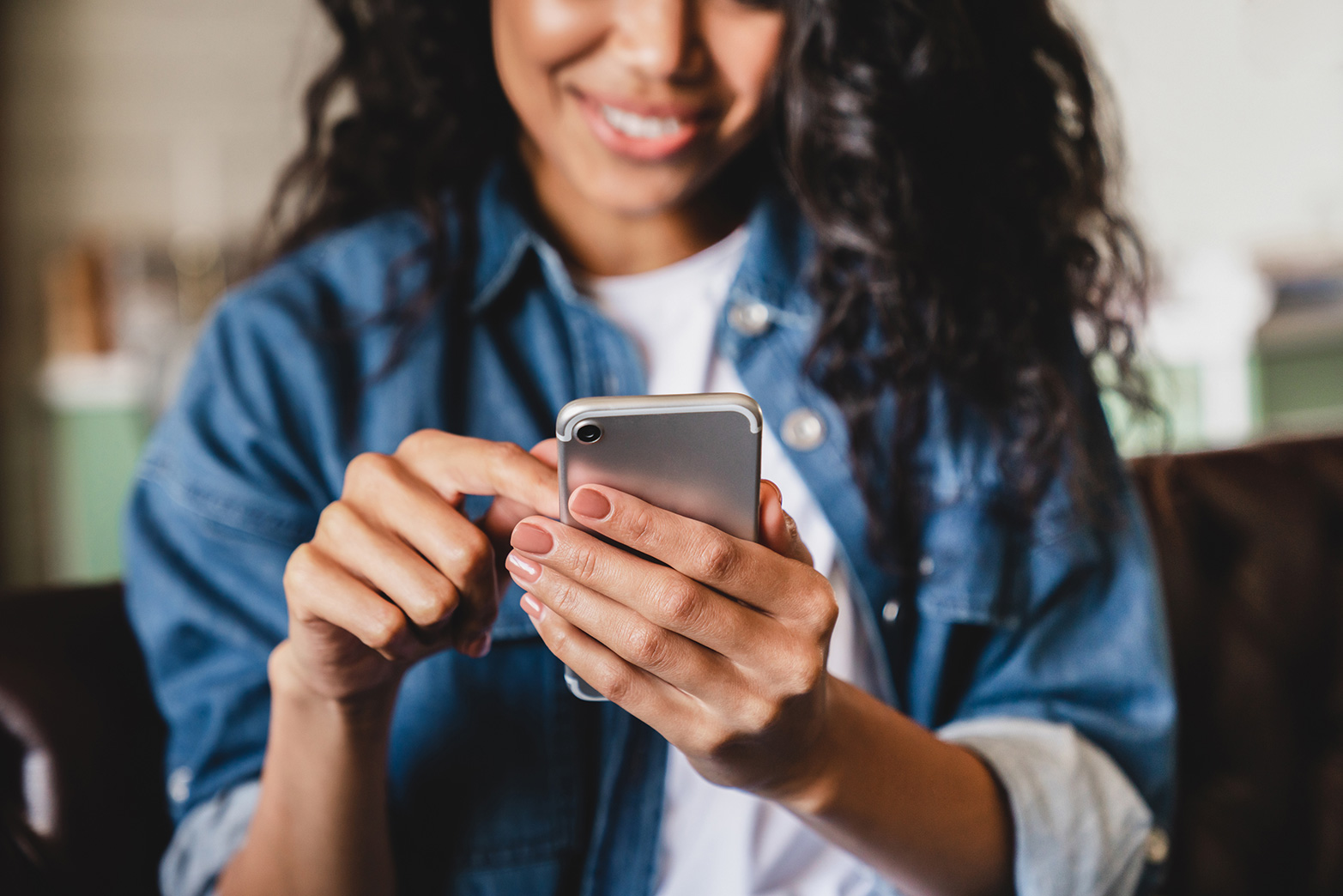 Smiling young woman holding a smartphone