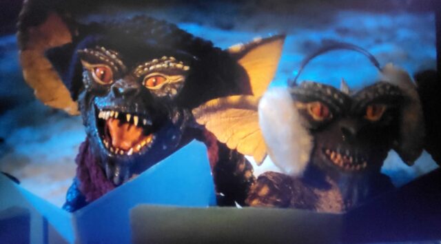 The Gremlins sing Christmas carols to Mrs. Deagle in a scene from Gremlins.