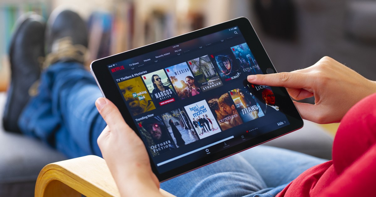 Person selecting a movie to stream on a tablet