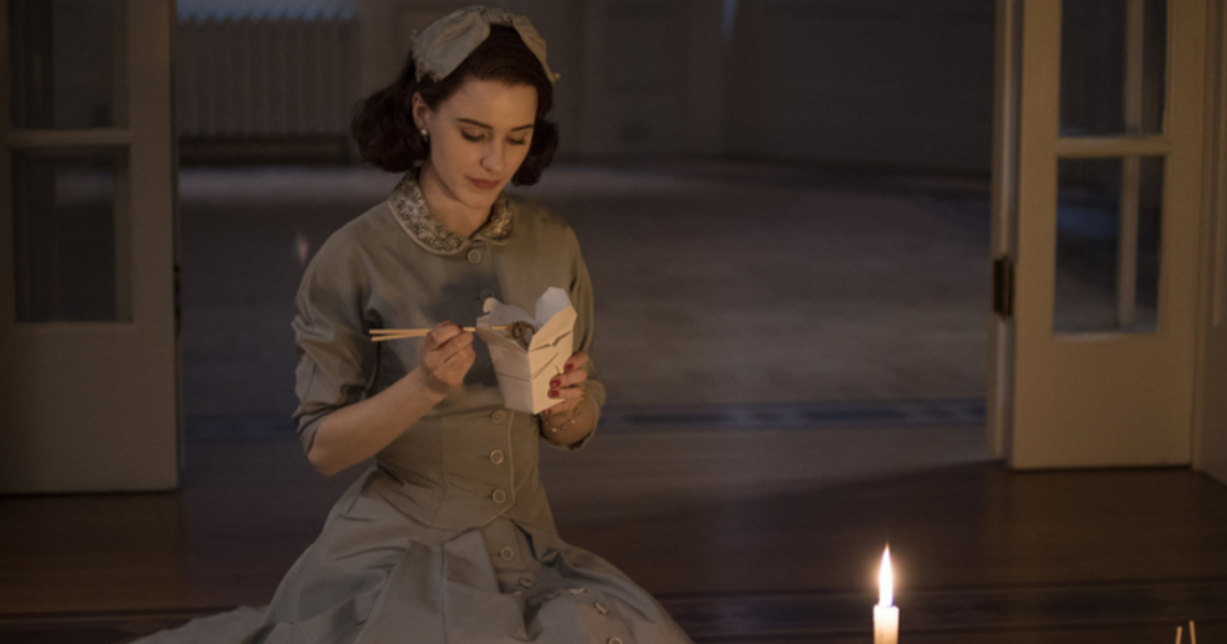 Mrs. Maisel eats Chinese food by candle light
