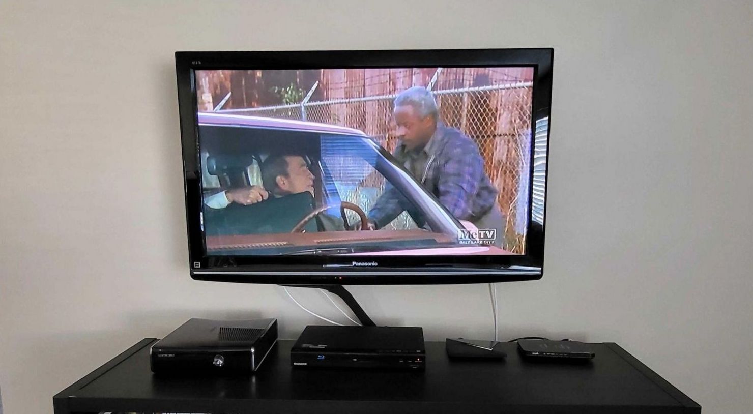 A wall-mounted TV with the Mohu Leaf 50’s cables sticking out.