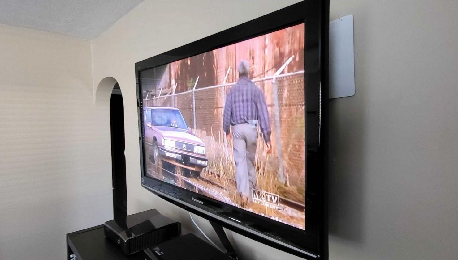The Mohu Leaf 50 concealed behind a wall-mounted TV.