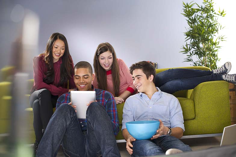 A group of young adults watching streaming TV on a tablet