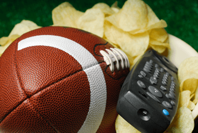 Football in a potato chip bowl with T V remote