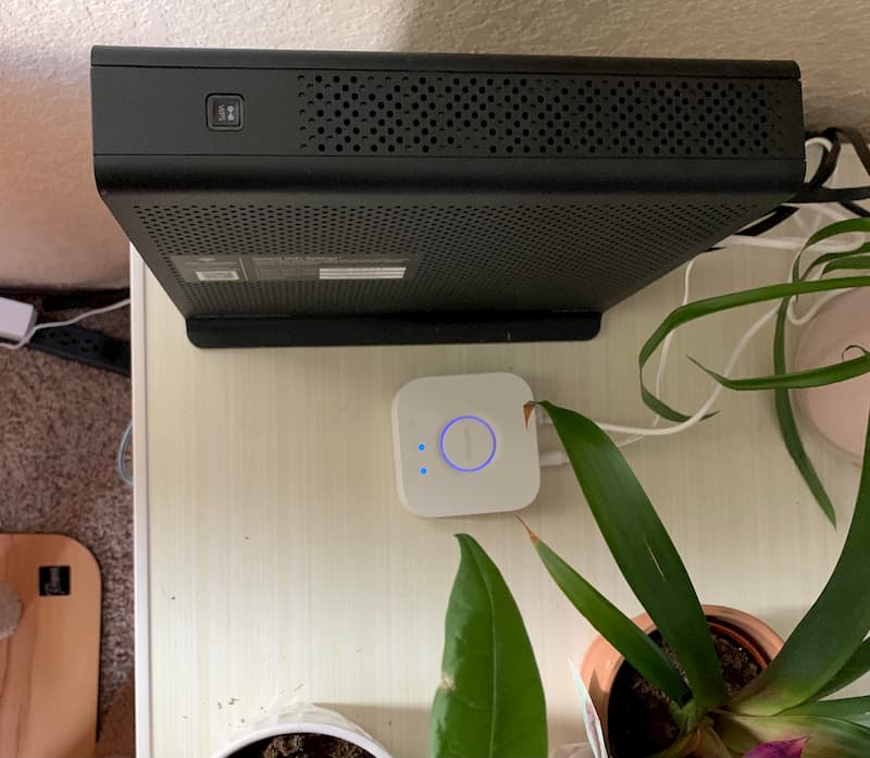 An Xfinity xFi modem/router on a desk with a plant.